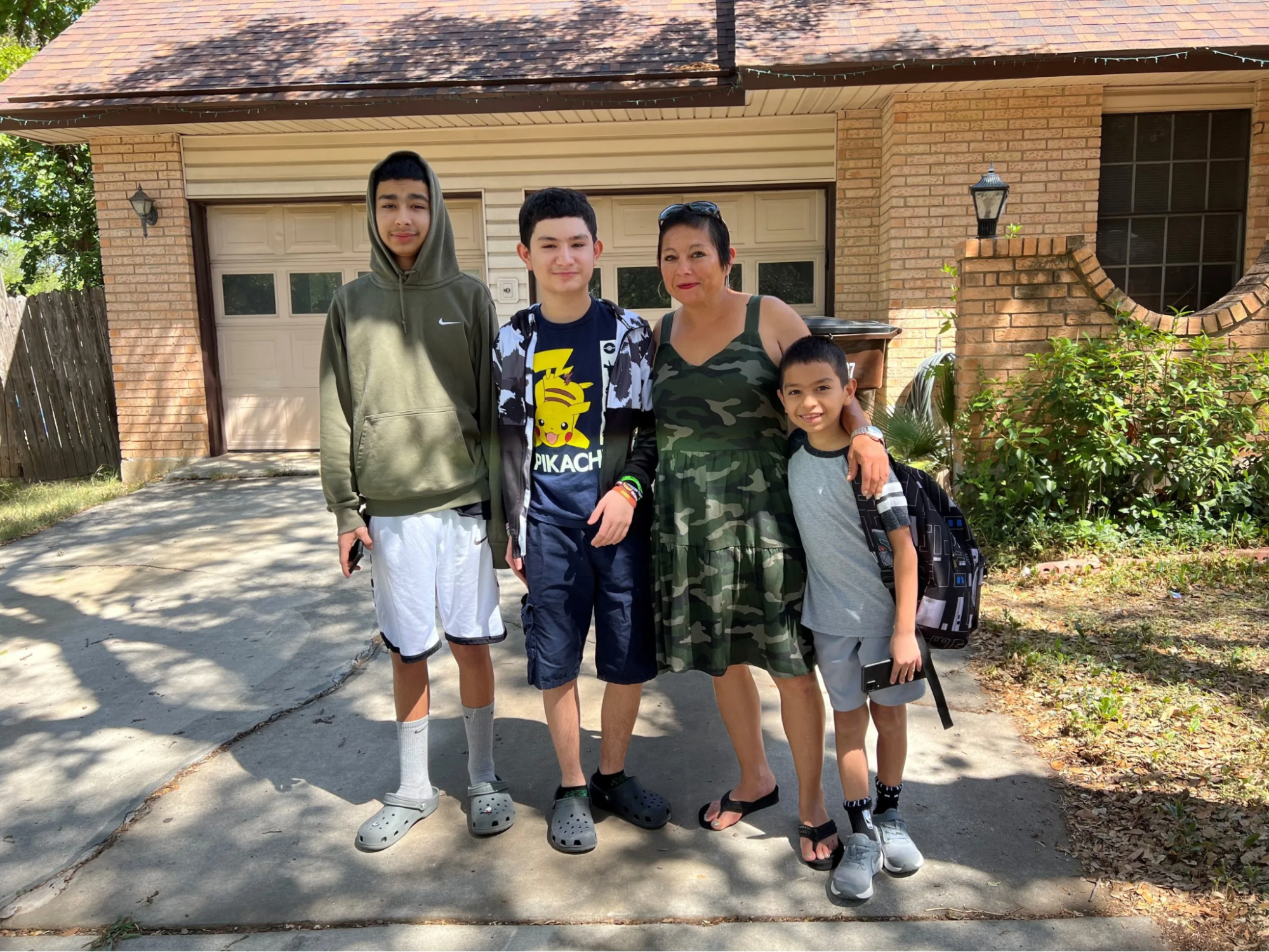 Mom and three kids photographed outside a house