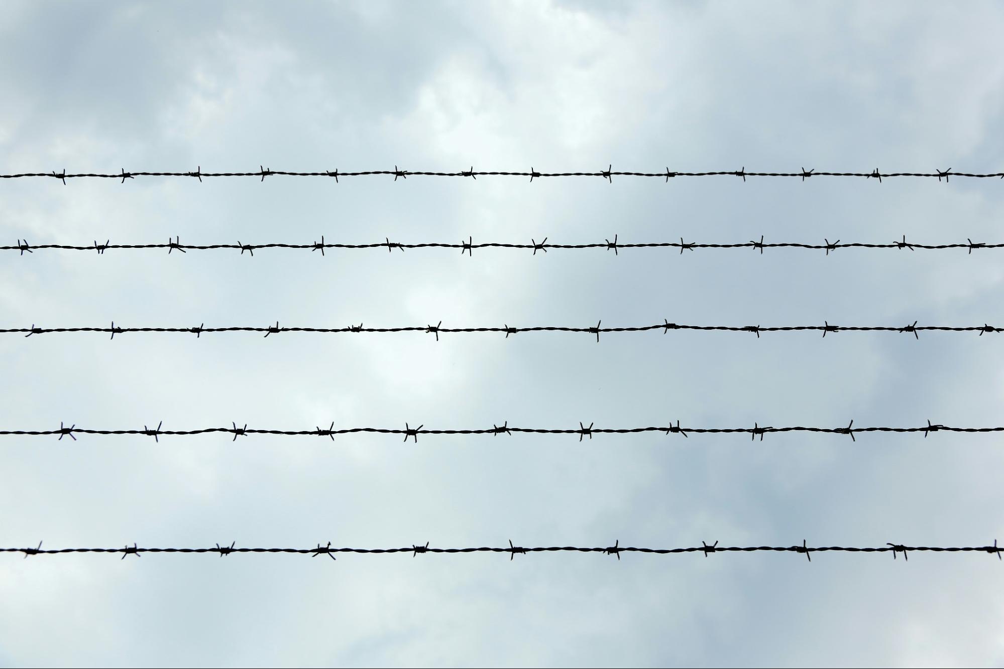 prison security wire (barbed wire) against a blue sky