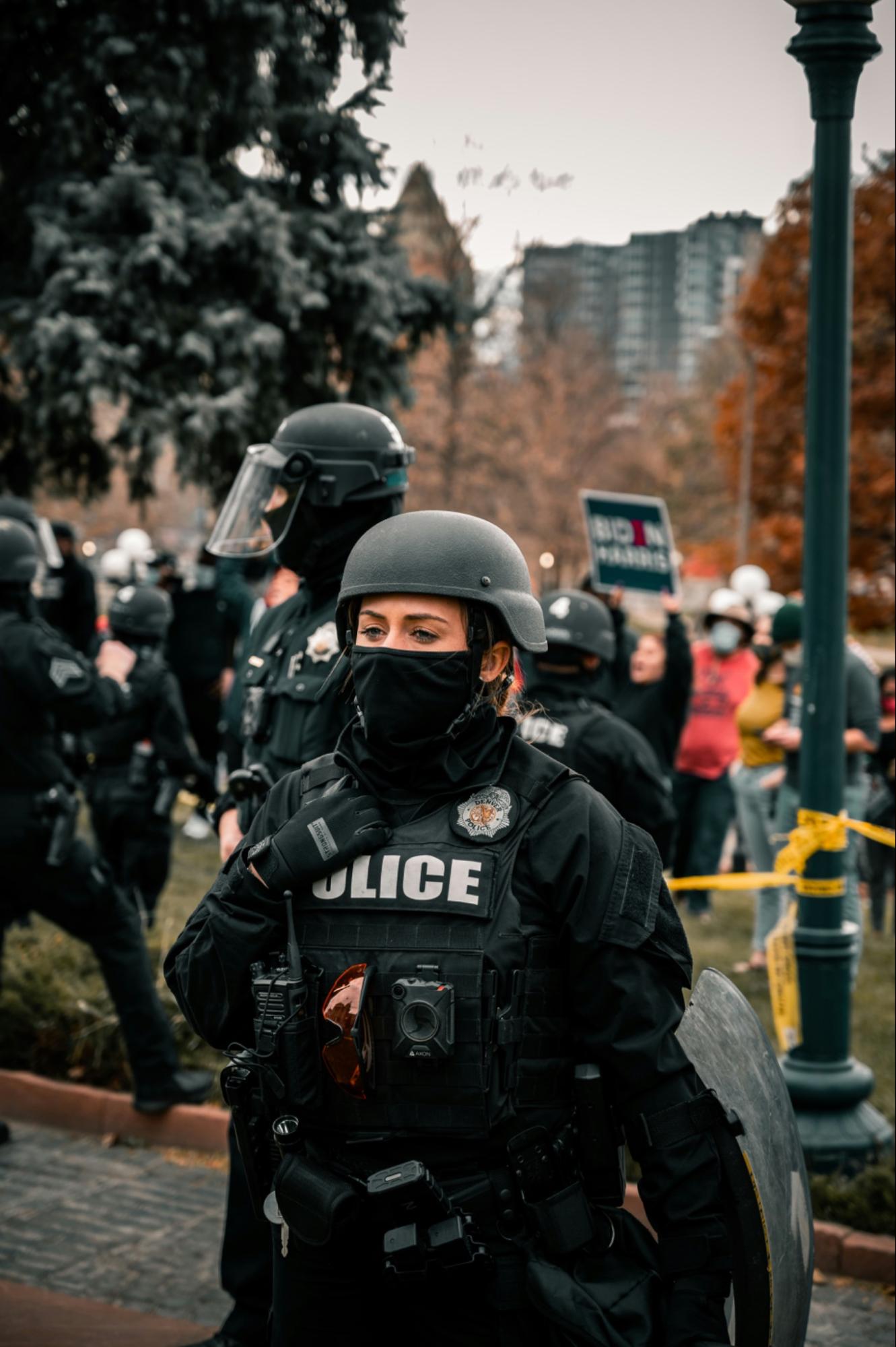 Woman police officer in tactical gear including helmet and mask