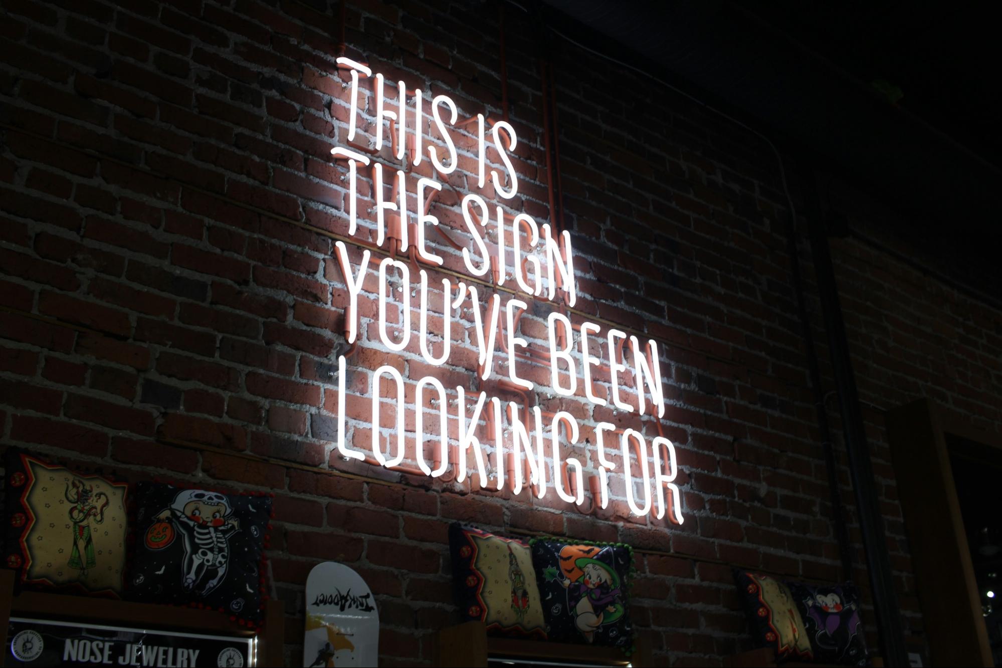 a lighted sign reading “This is the Sign You’ve Been Looking For.”