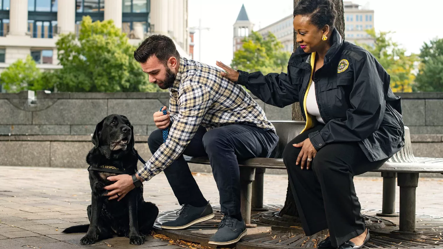 An FBI worker sits next to a man who pets the FBI dog