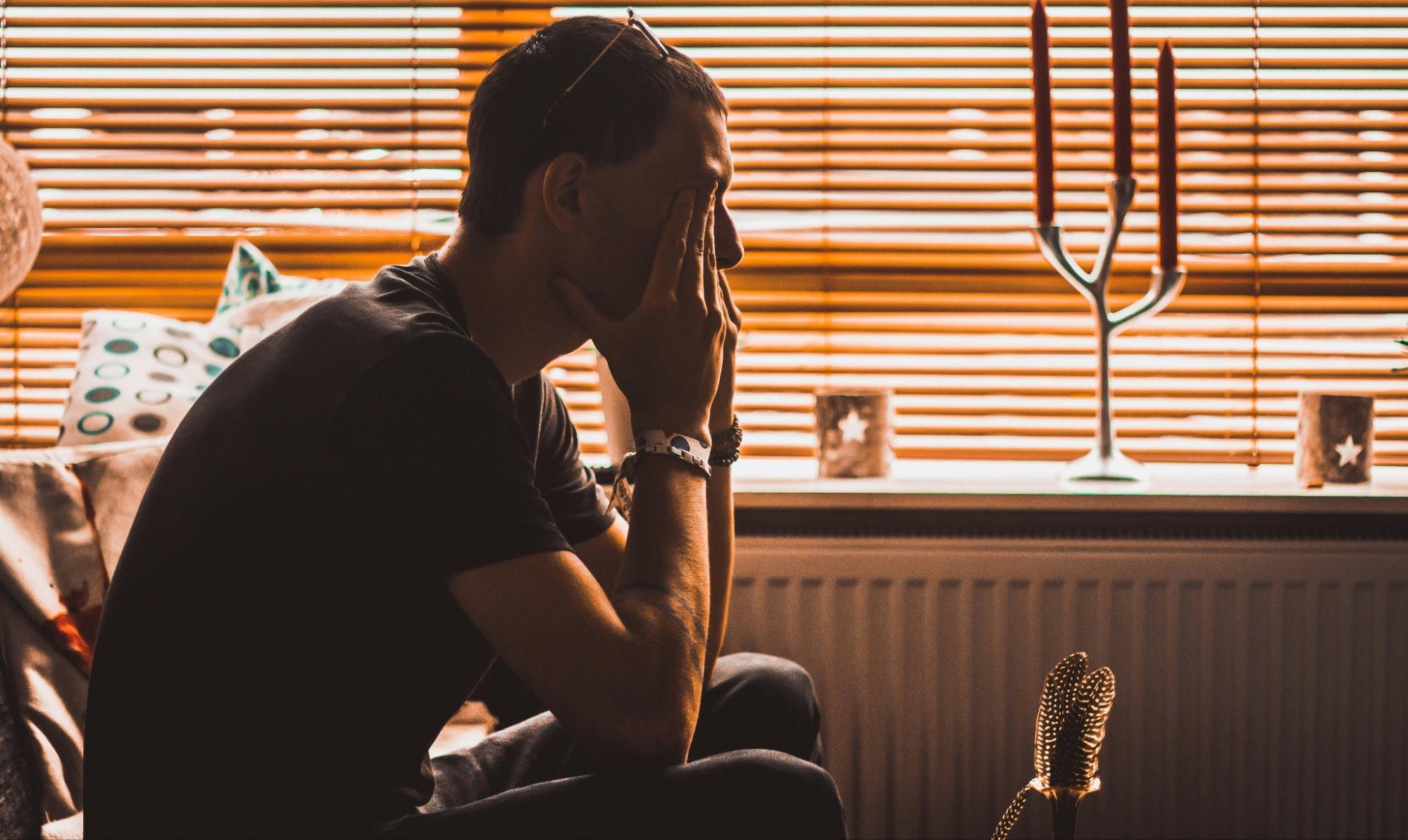 A person appears stressed while sitting alone