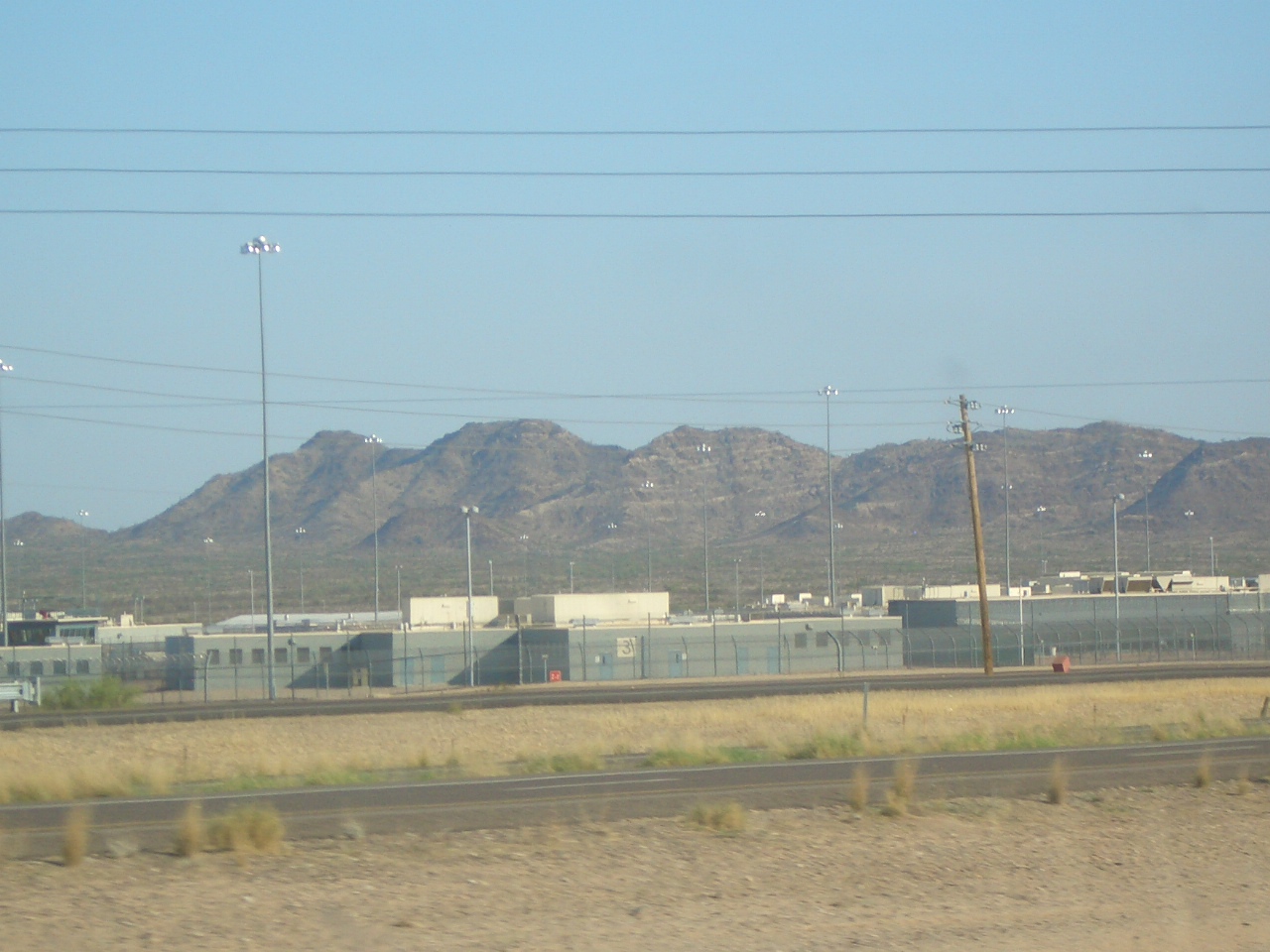 An Arizona prison facility in a desert-like landscape with mountains behind it.