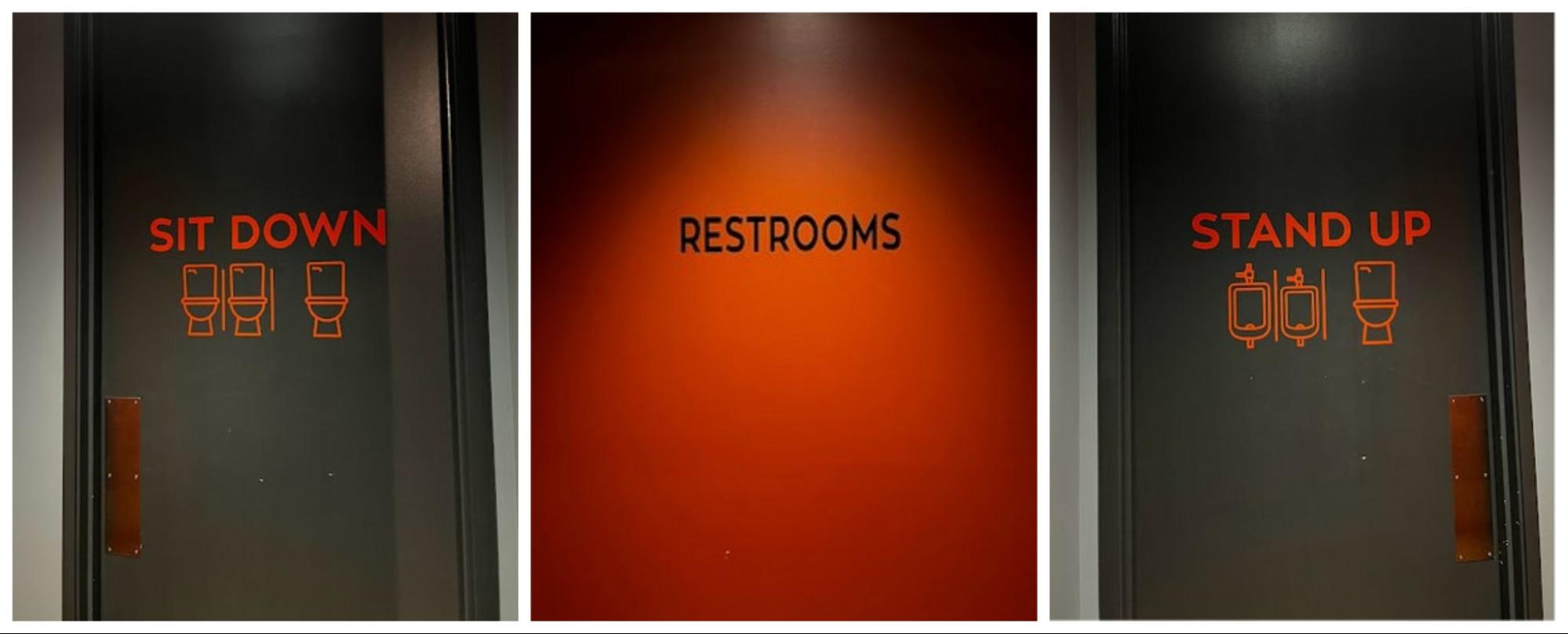 Three black and red bathroom doors read "sit down," "restrooms," and "stand up."