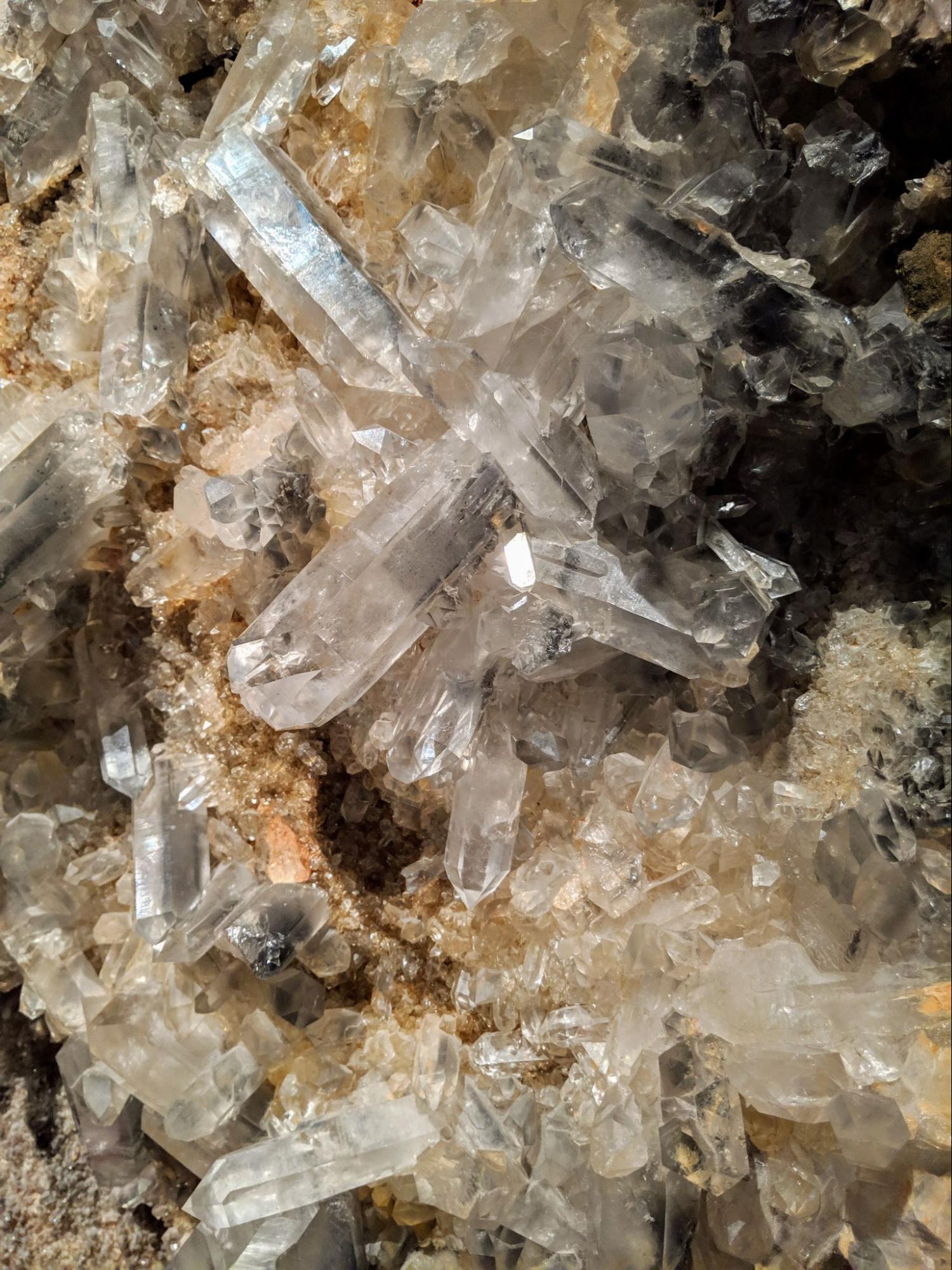 A crystalline mineral formation with clear crystals in a gray matrix