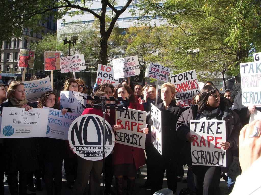 People holding signs asking others to take rape seriously