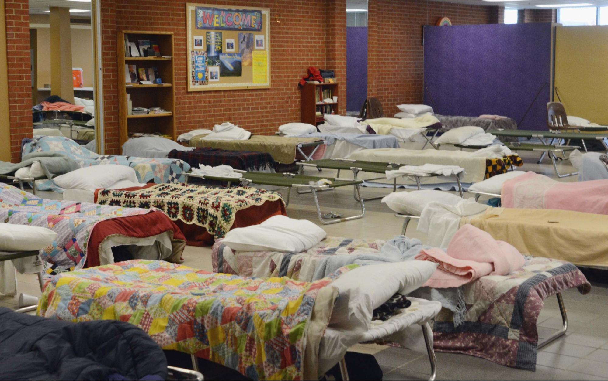 School interior repurposed as shelter with made-up cots