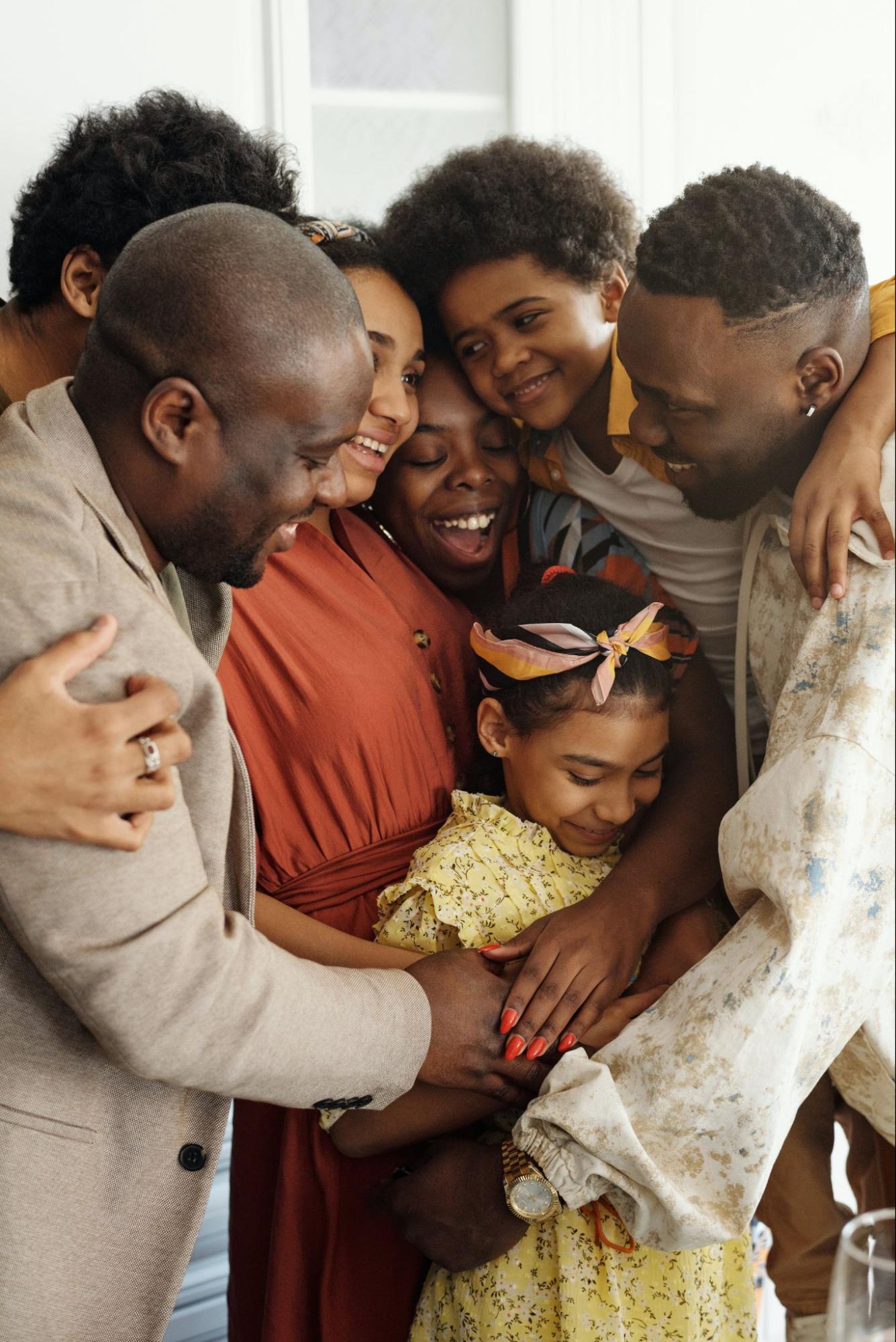 A group of smiling, hugging, people of various ages