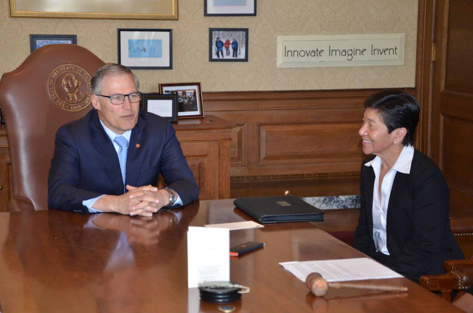 Governor Inslee and Judge Yu sit at an ornate table with a judge's mallet.