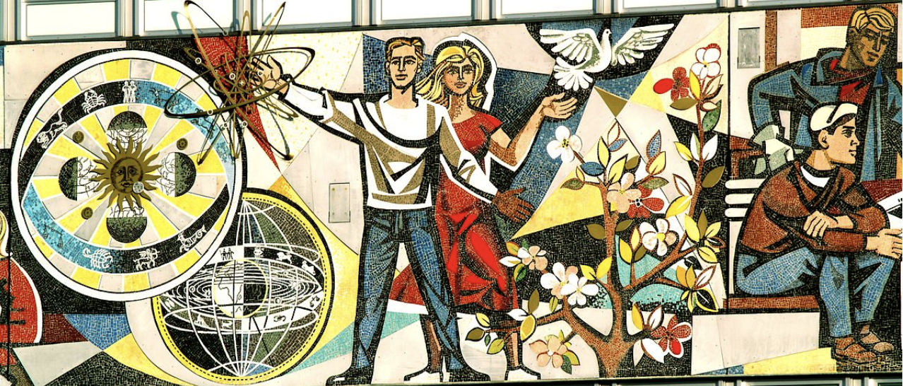 a mural depicting people surrounded by various objects : a colorful tree, a dove, spherical images of the globe and solar system.
