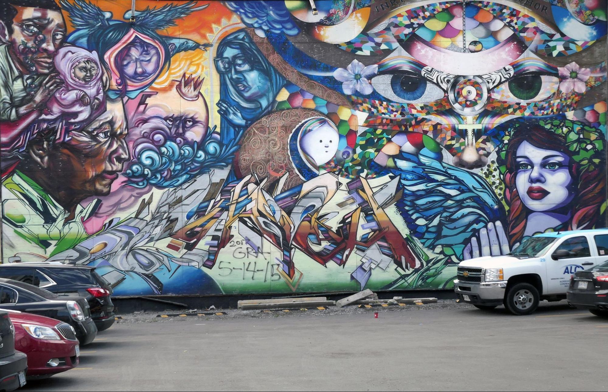 A colorful painted mural with many images related to spirituality, religion and culture.