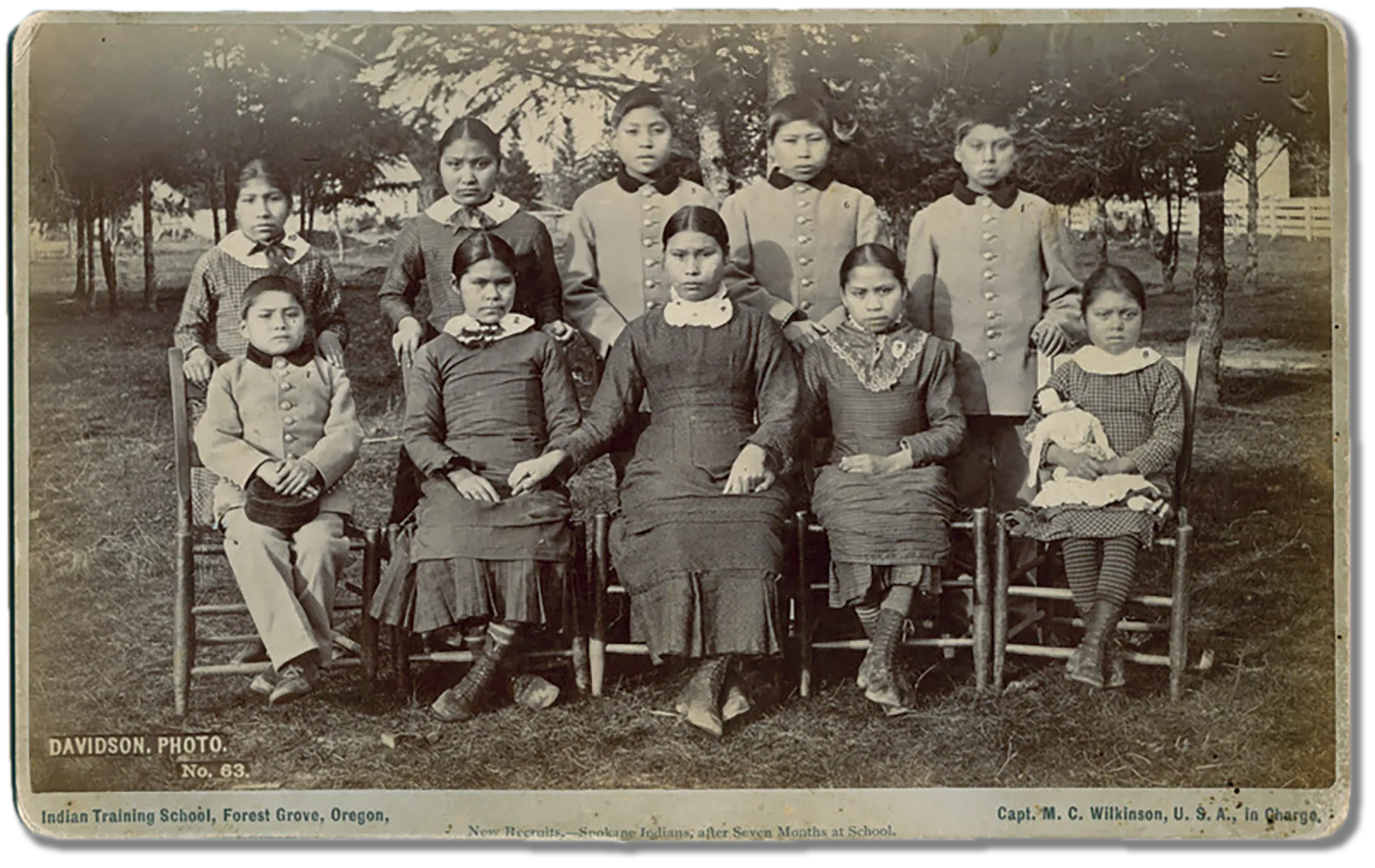 Seven months later Ten of the Eleven students from the previous photo are now posing in suits and dresses rather than their own clothing.