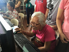 A senior citizen working on a computer. 