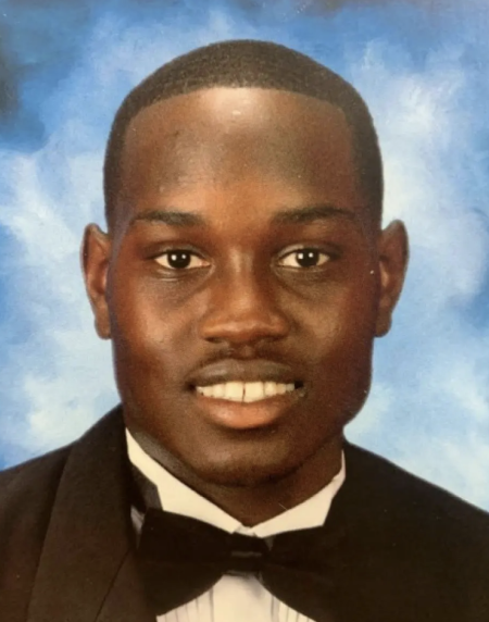 A professional class photo of Ahmaud Arbery smiling in a suit with a bow tie.
