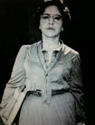A black and white photo of Susie Guillory Phipps in a dress with a serious expression on her face.