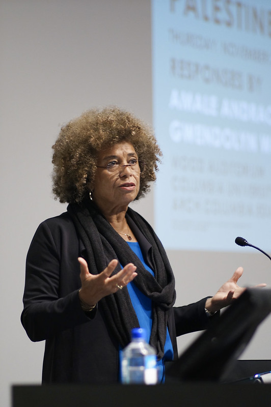 Angela Davis at a podium speaking to a crowd