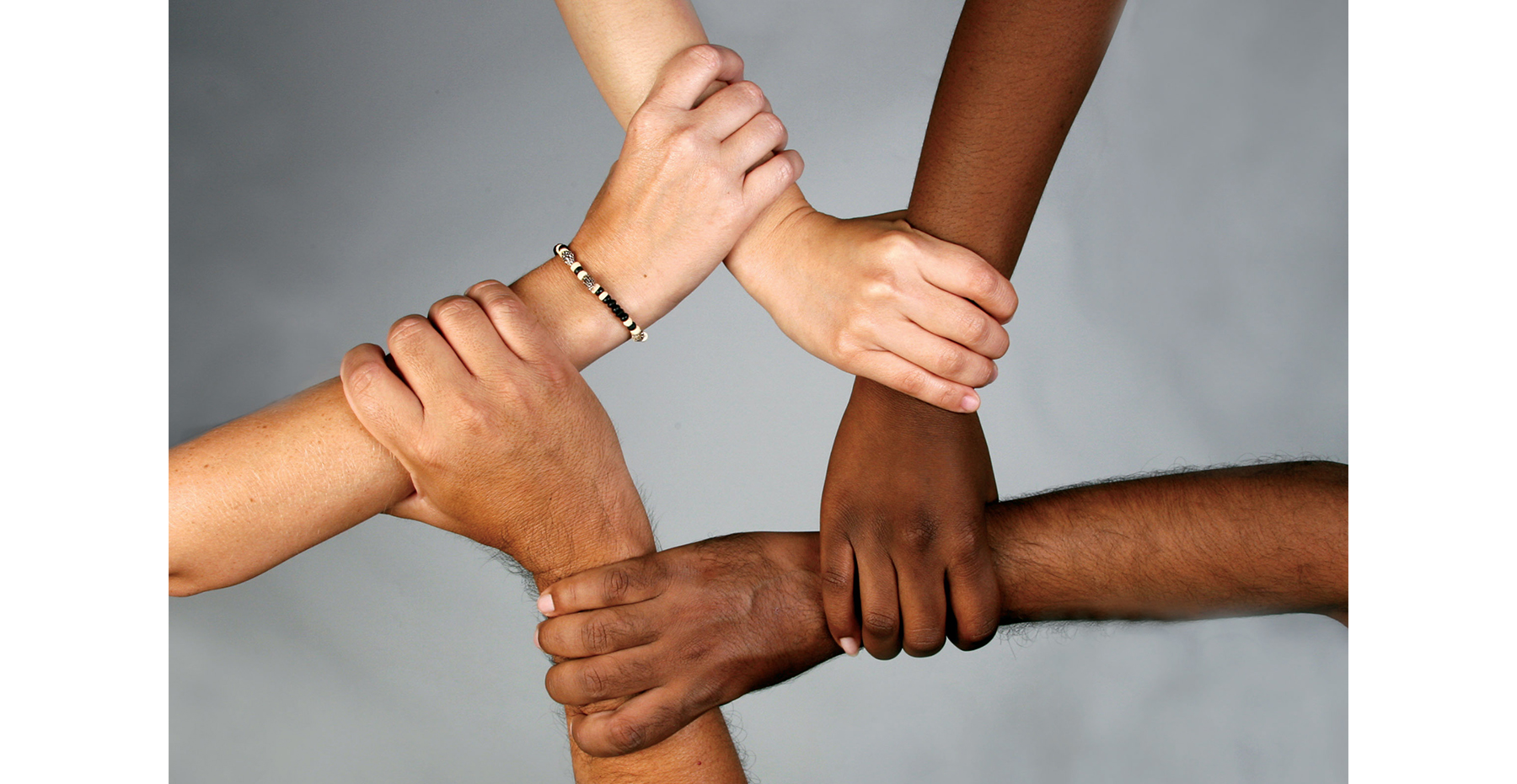 People with different skin tones interlock arms in a star shape