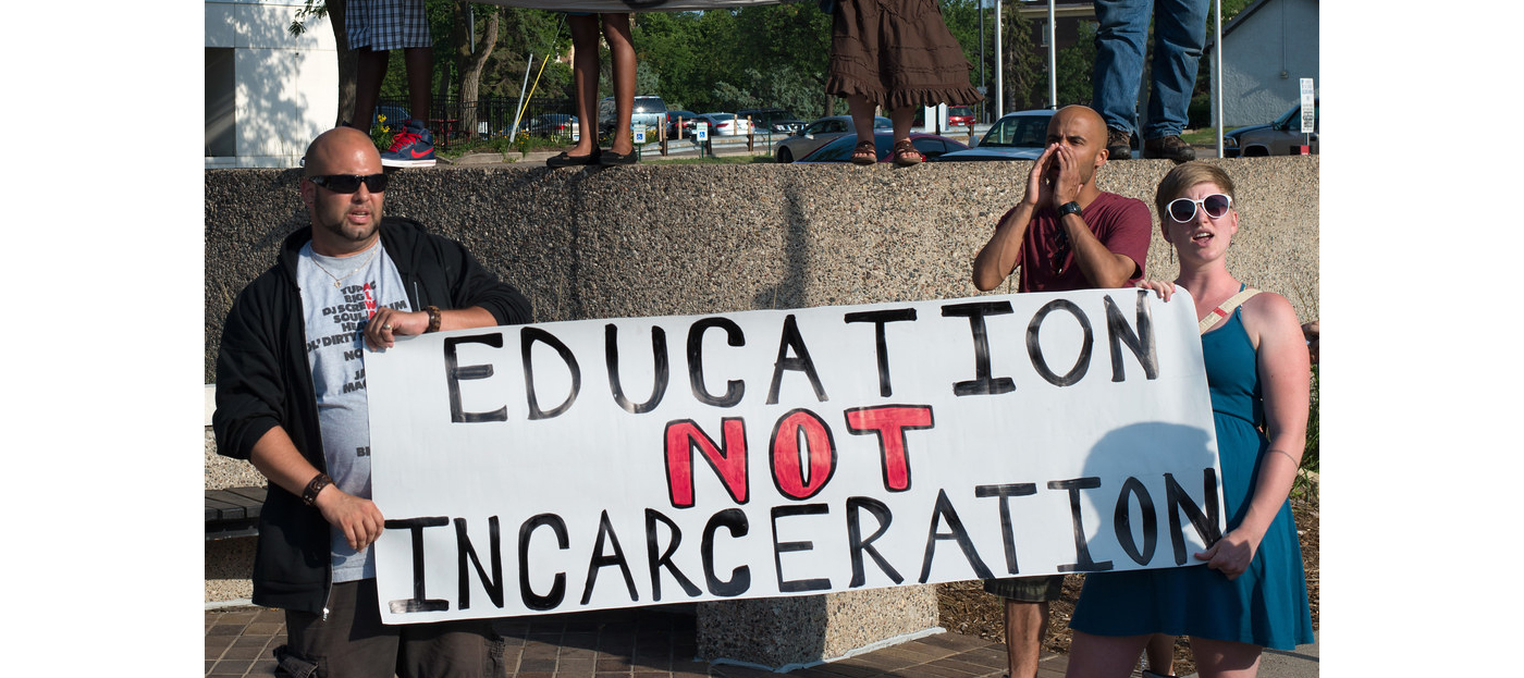 Protest against police brutality in Uptown, banners reading 'Stop Police Brutality' and 'Education Not Incarceration'.