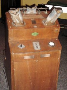 photo of wooden box with dials, switches, and metal parts coming out of it.