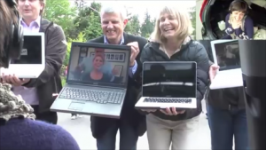 people holding laptop computers with other people on the screens