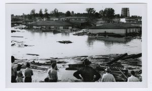 people looking at damaged and flooded houses