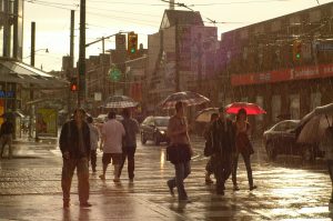 people crossing the street in the rain