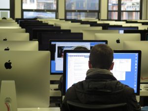 man working at a computer in a computer lab