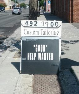 Photo of a sign that reads "Good help wanted." The word good is incorrectly in quotation marks.