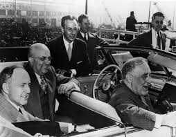 Photo of Governor Sprague, Henry Kaiser, and President Roosevelt sitting in a car talking to on-lookers.